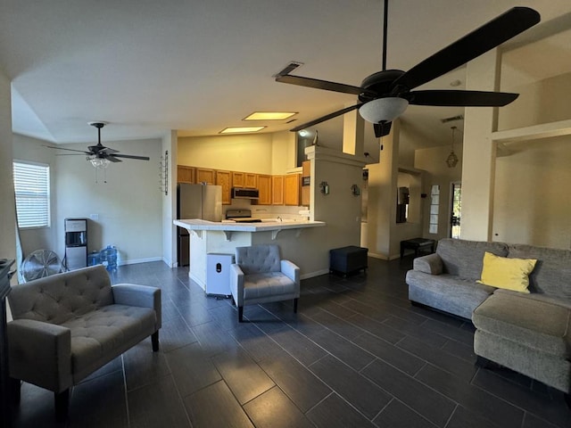 living room with ceiling fan, a healthy amount of sunlight, and high vaulted ceiling