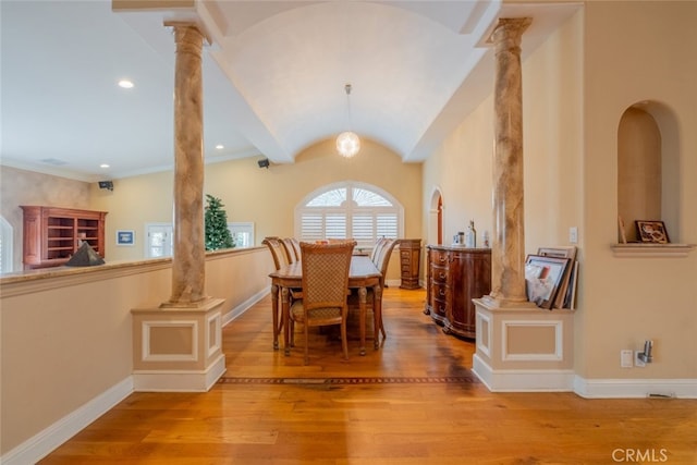 dining area featuring decorative columns, lofted ceiling, and hardwood / wood-style floors