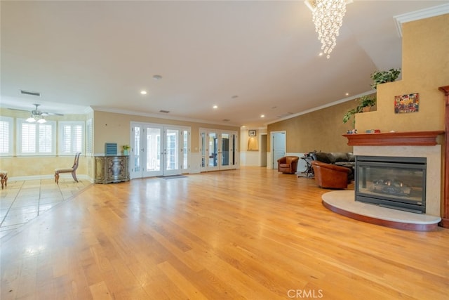 living room with crown molding, light wood-type flooring, and french doors