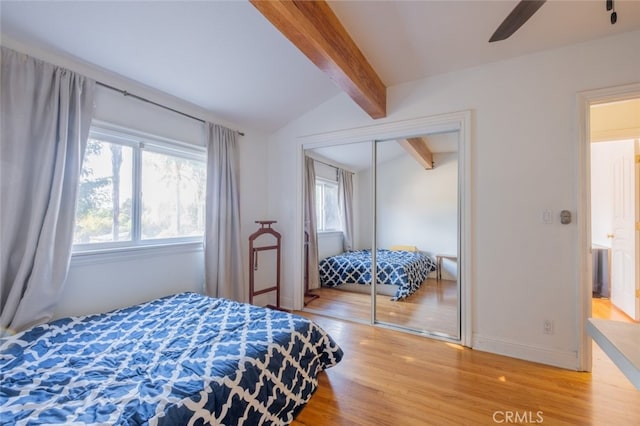 bedroom featuring vaulted ceiling with beams, wood-type flooring, a closet, and ceiling fan