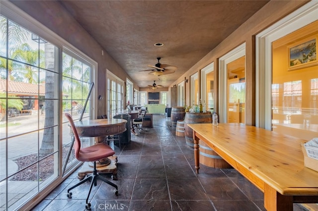 sunroom / solarium featuring ceiling fan