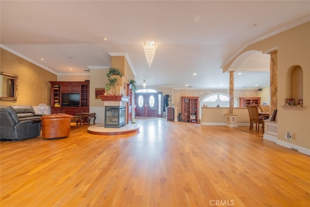 living room featuring ornamental molding, light hardwood / wood-style floors, and ornate columns