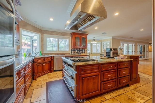 kitchen with island range hood, backsplash, ornamental molding, a kitchen island with sink, and stainless steel appliances