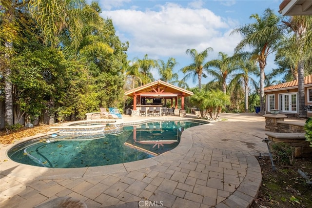 view of pool with a gazebo, a patio, an outdoor bar, and an in ground hot tub