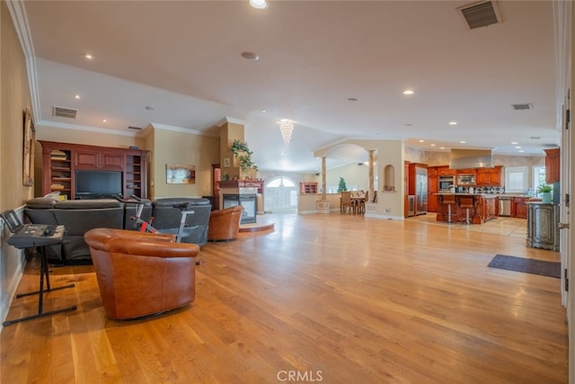 living room featuring crown molding and light wood-type flooring