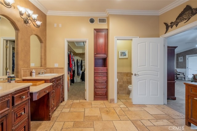 bathroom with ornamental molding, toilet, and vanity