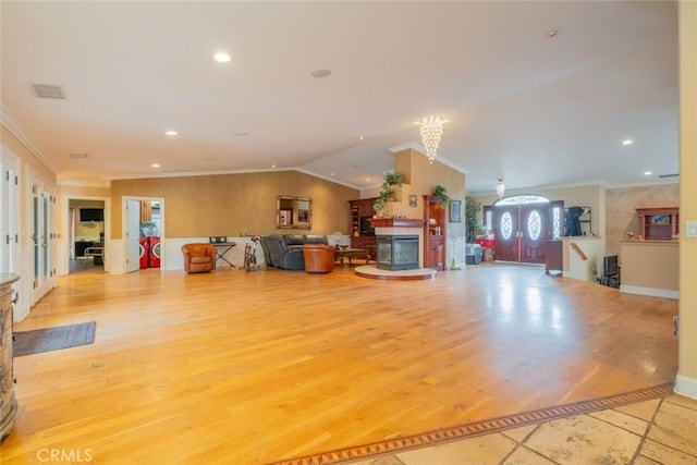 living room featuring ornamental molding, light hardwood / wood-style floors, and vaulted ceiling