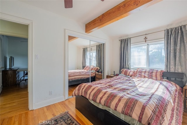 bedroom with hardwood / wood-style flooring, ceiling fan, a closet, and vaulted ceiling with beams