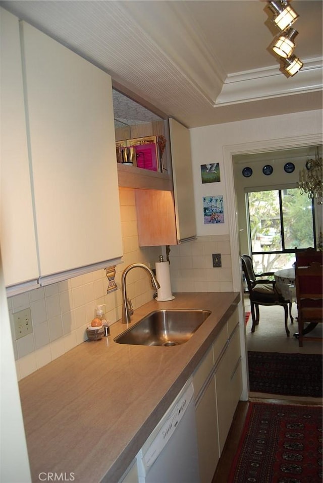 kitchen featuring ornamental molding, sink, white dishwasher, and decorative backsplash