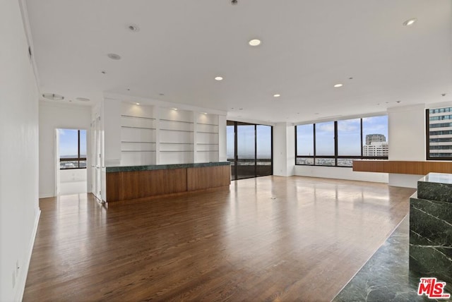 unfurnished living room featuring wood-type flooring and a wealth of natural light