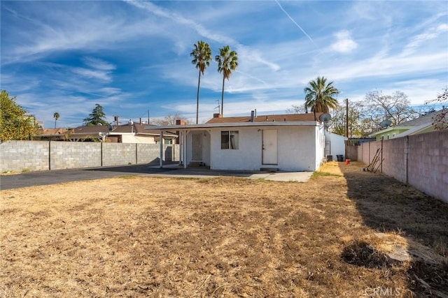 rear view of property featuring a lawn