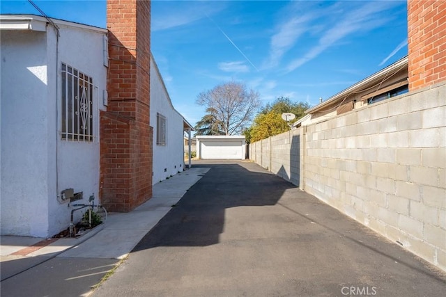 view of property exterior featuring a garage and an outbuilding