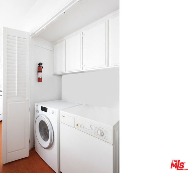 clothes washing area with cabinets and washing machine and dryer