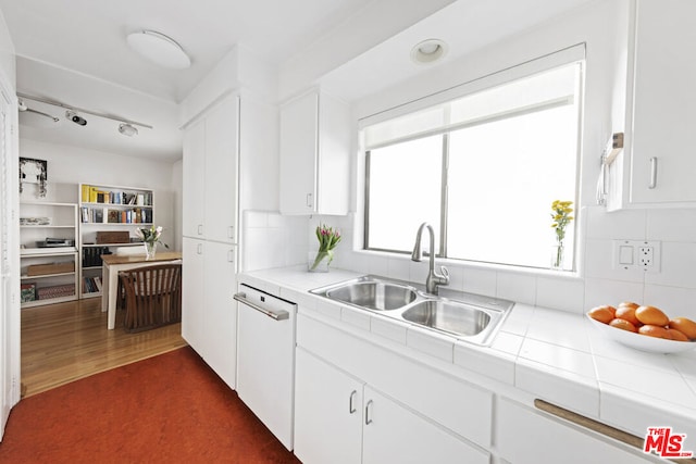 kitchen with sink, white cabinetry, dark hardwood / wood-style floors, white dishwasher, and tile countertops