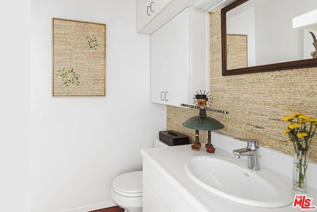 bathroom with tasteful backsplash, vanity, and toilet