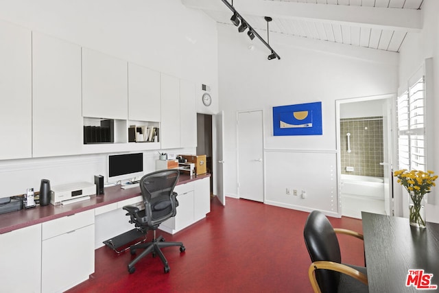 home office featuring built in desk and lofted ceiling with beams