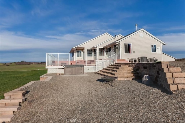 view of front facade featuring a hot tub, a patio, and central air condition unit