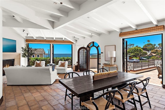 dining room featuring lofted ceiling with beams and a healthy amount of sunlight