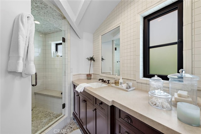 bathroom with lofted ceiling, a shower with door, and vanity