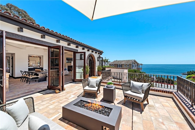 view of patio featuring a water view and an outdoor fire pit