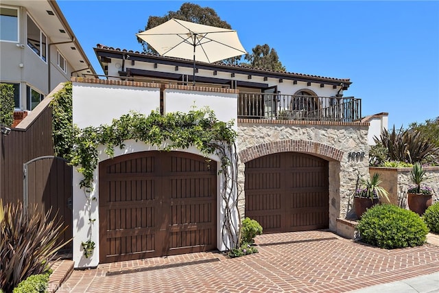 mediterranean / spanish home featuring a balcony and a garage