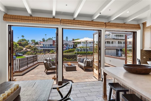 doorway to outside featuring beamed ceiling