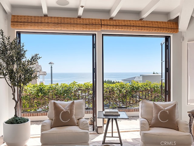 sunroom / solarium featuring beamed ceiling and a water view