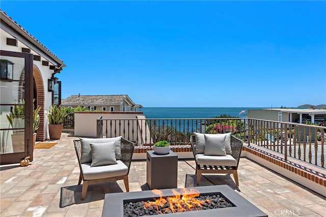 view of patio featuring a fire pit and a water view