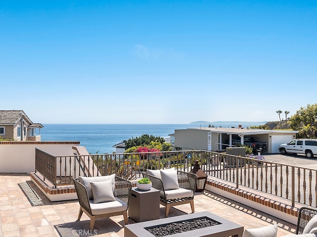 exterior space featuring a patio, a water view, and an outdoor fire pit