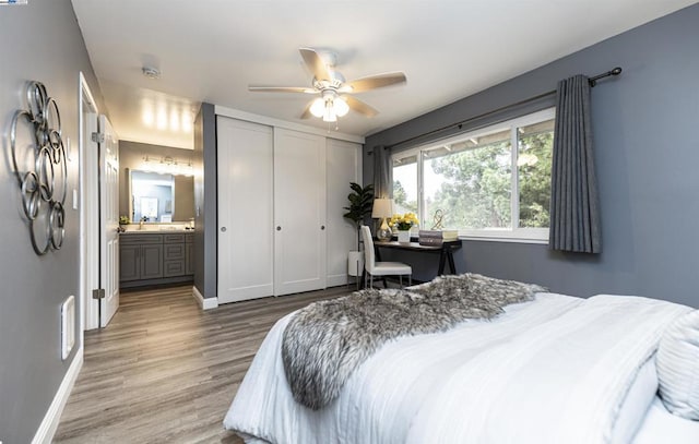 bedroom with a closet, hardwood / wood-style floors, ceiling fan, and ensuite bath