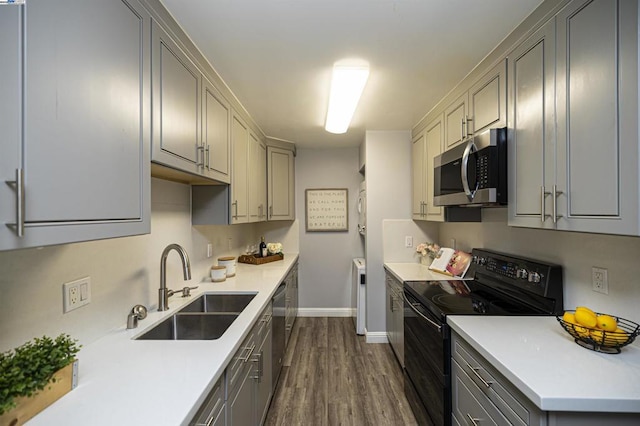 kitchen featuring gray cabinetry, sink, dark wood-type flooring, and appliances with stainless steel finishes