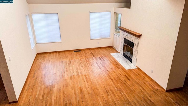 unfurnished living room featuring a fireplace and light hardwood / wood-style floors