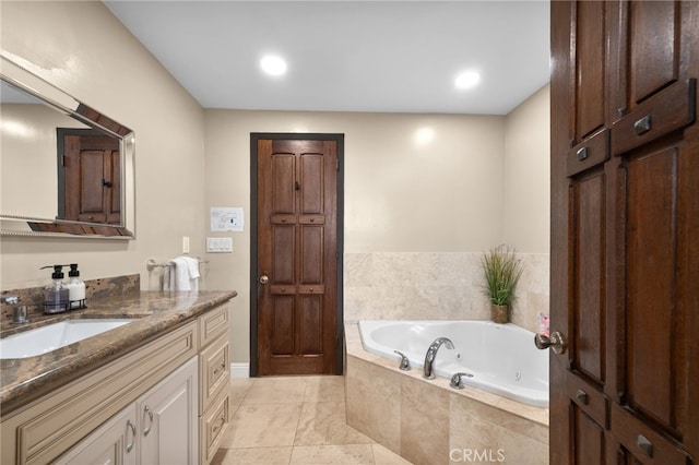 bathroom with a relaxing tiled tub, vanity, and tile patterned floors