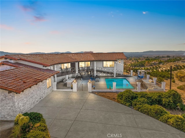 pool at dusk with a patio