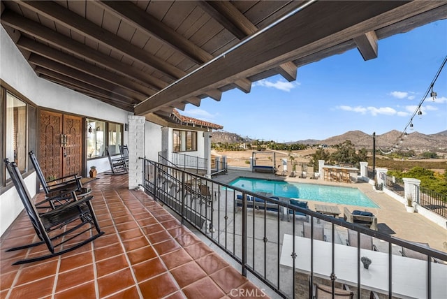 balcony with a mountain view and a patio area