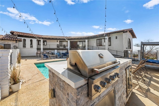 rear view of house with area for grilling, a swimming pool, and a patio