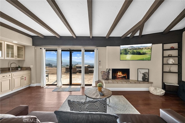 living room with sink, dark wood-type flooring, and beamed ceiling