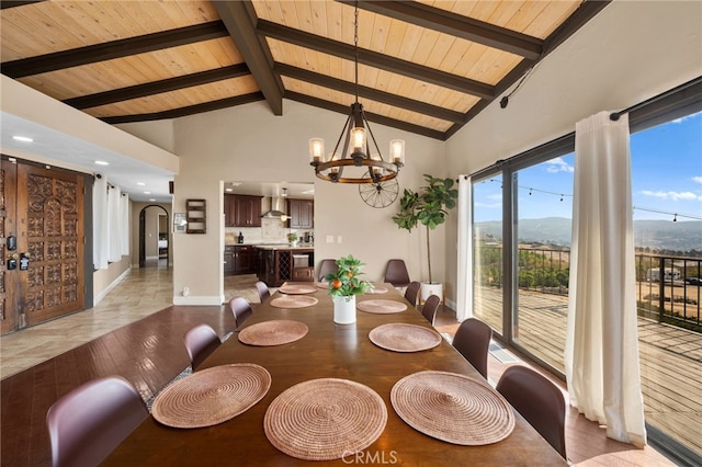 dining room with wooden ceiling, beam ceiling, a mountain view, and a notable chandelier