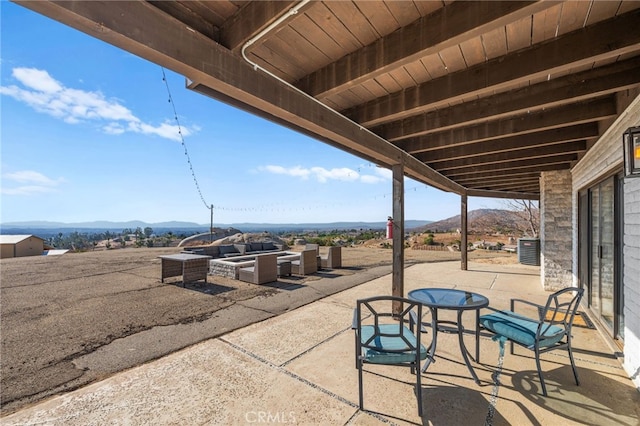 view of patio / terrace featuring a mountain view and an outdoor living space with a fire pit