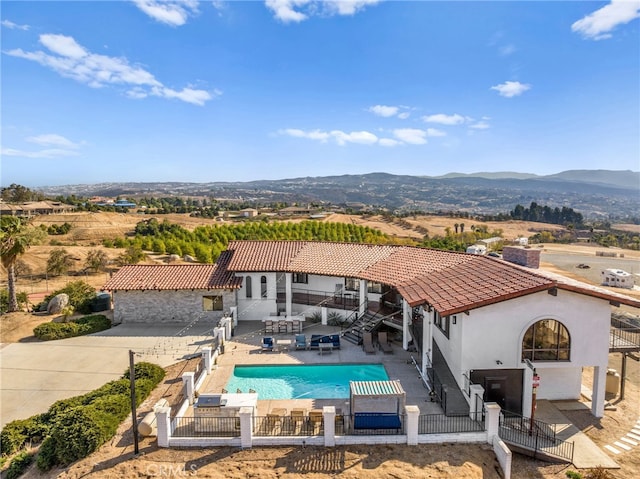 back of property featuring a mountain view and a patio area