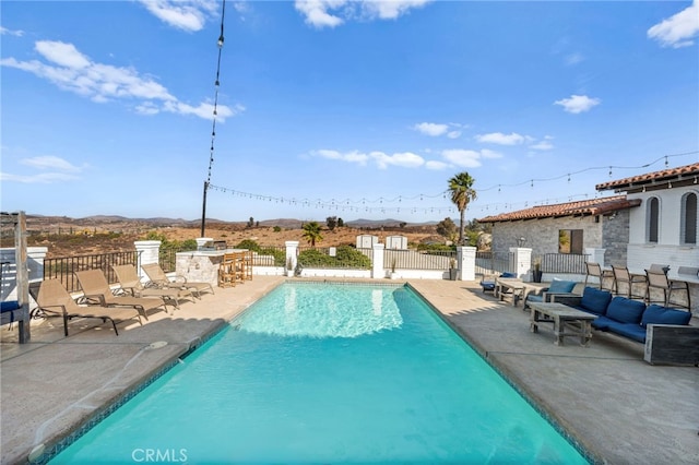 view of pool featuring a bar and a patio