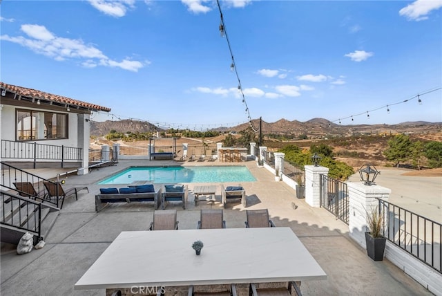 view of swimming pool featuring a mountain view and a patio