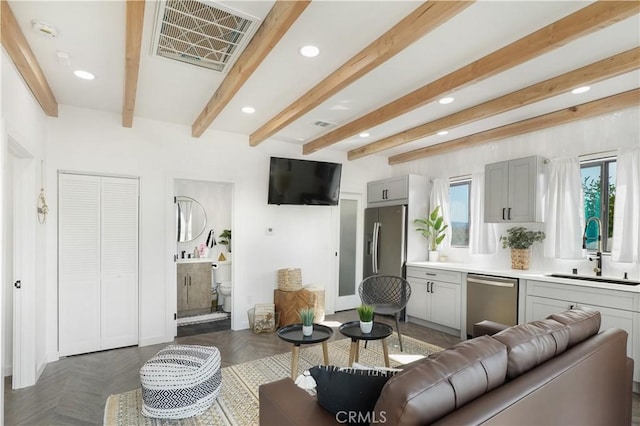 living room with beam ceiling, sink, and dark parquet flooring