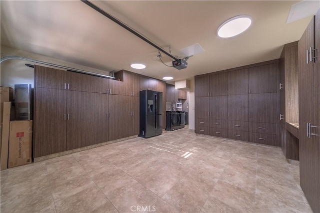 garage featuring a garage door opener and black refrigerator with ice dispenser