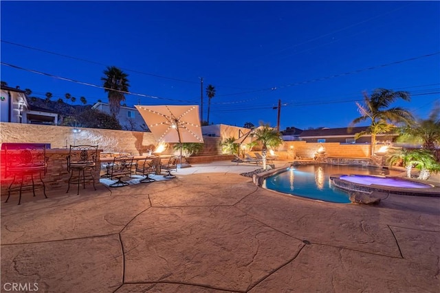 view of swimming pool featuring a patio, exterior bar, and an in ground hot tub