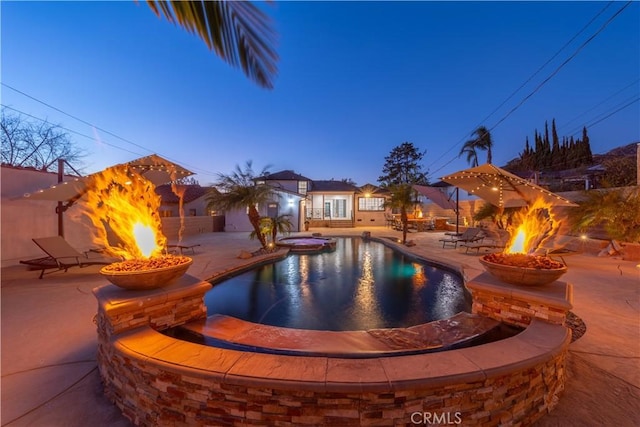 pool at dusk featuring a patio area and an outdoor fire pit