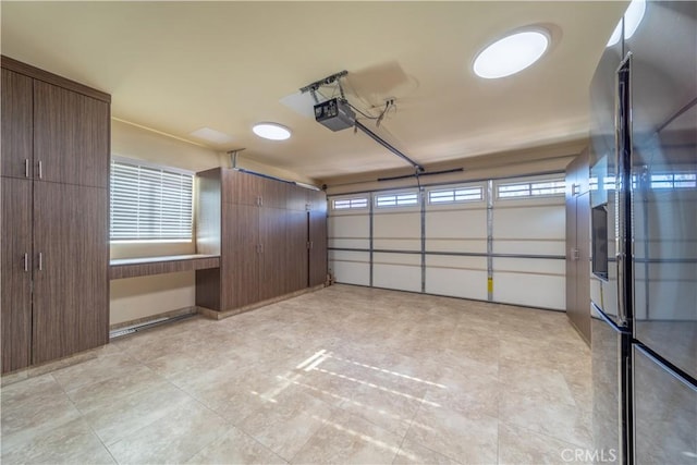 garage featuring a garage door opener and stainless steel refrigerator