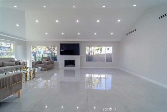 living room with a healthy amount of sunlight, a fireplace, and high vaulted ceiling