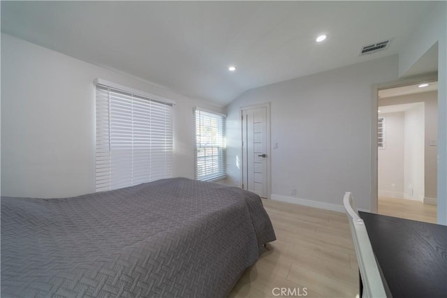 bedroom with lofted ceiling and light hardwood / wood-style floors