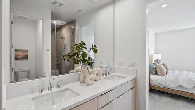 bathroom featuring vanity, an enclosed shower, and toilet